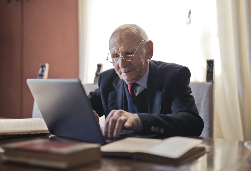 great passive income idea - older man writing a book using laptop